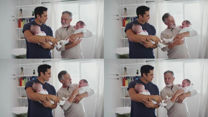 年轻的西班牙裔男子和他的高级父亲抱着他的两个男婴在家里，特写