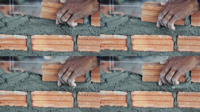 近距离手工专业建筑工人在新工业场地、建筑行业和砖石概念中铺设砖的4k慢动作镜头