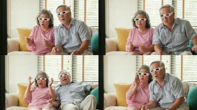 亚洲高级夫妇戴着3d眼镜在客厅看电影。老年夫妇一起看电影时情绪激动。有生活方式、假期、娱乐观念的人。