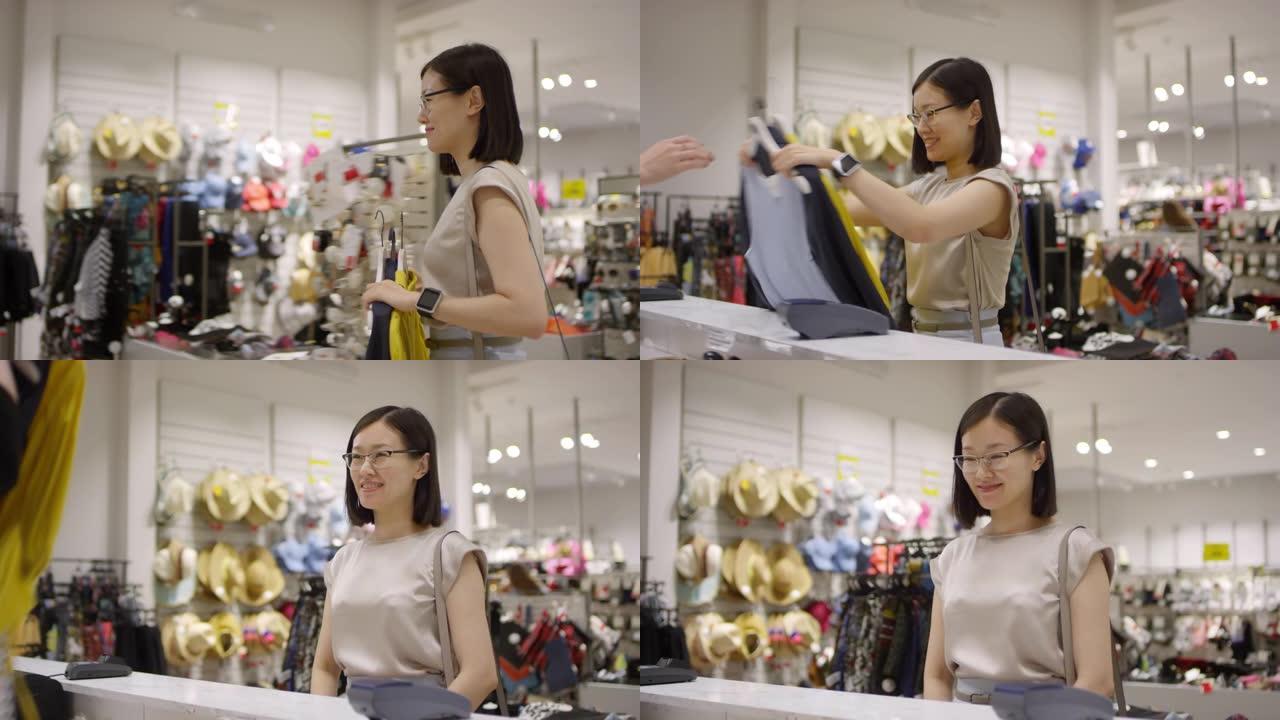 亚洲妇女背着衣服通过商店结帐