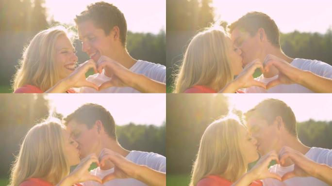 慢动作: 微笑的男人和女人亲吻，同时用手指做心形。