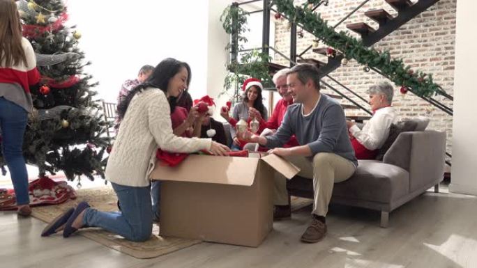 幸福的家庭从盒子里拿出圣诞装饰品，放在圣诞树上