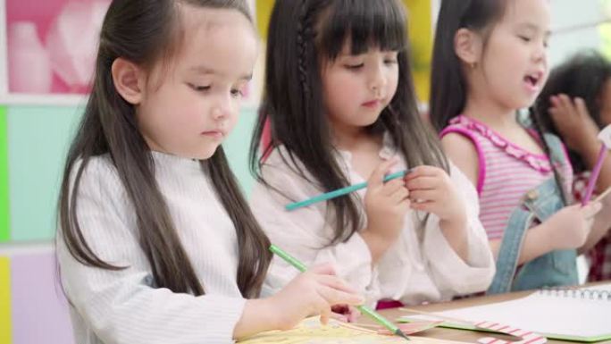 一群孩子在教室里画画，多民族的年轻男孩和女孩在小学快乐有趣的学习和在纸上画画。孩子们在学校画画的概念