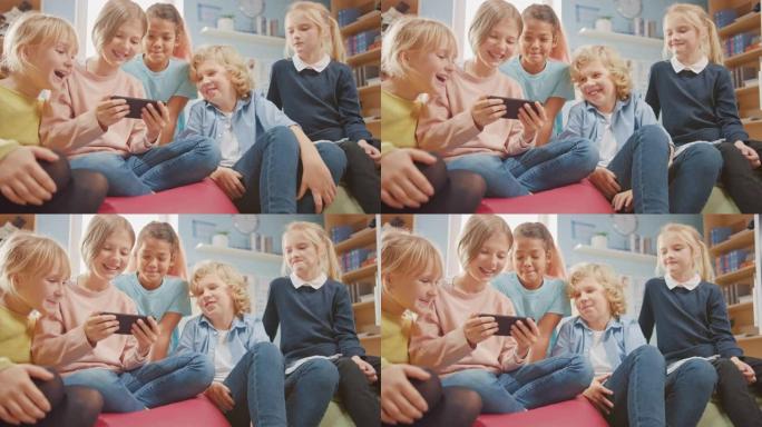 一群可爱的小孩坐在一起的豆袋上，使用智能手机聊天，玩得开心。孩子们在网上浏览，在手机上玩在线视频游戏