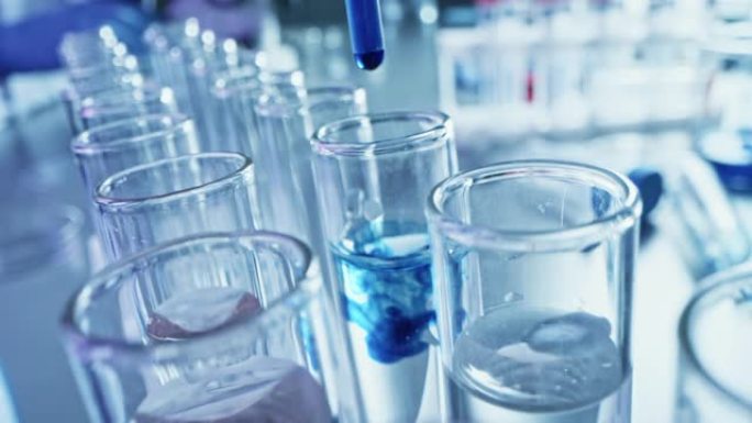 药剂学实验室: 移液器将蓝色液体滴入试管，医学研究，分析。科学实验室; 滴管用创新的DNA研究溶液填