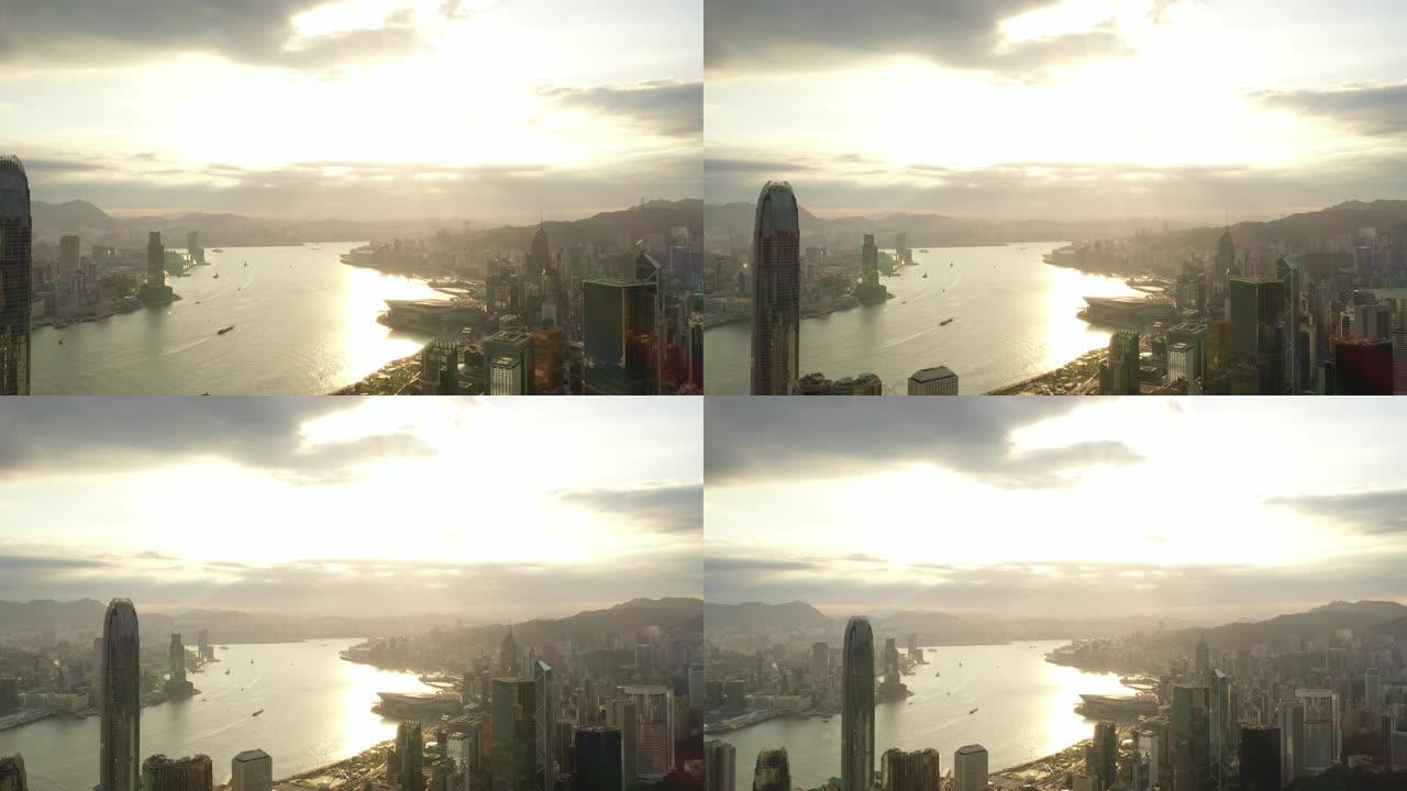 香港城市天际线和sunflares 4k股票视频的鸟瞰图日出。无人机正在向后飞行。
