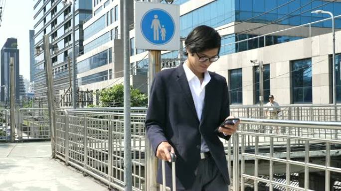 亚洲商人在现代城市外面使用智能手机