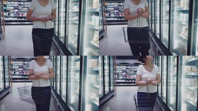 年轻的亚洲妇女带着购物篮穿过商店。