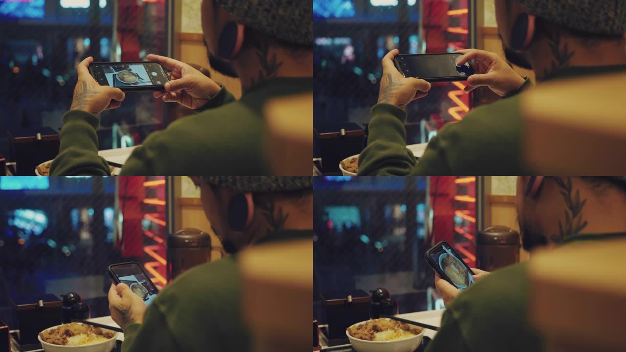 亚洲男子在餐厅用手机拍照咖喱牛肉饭。