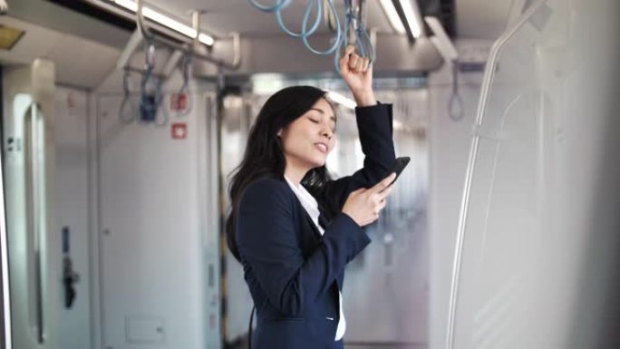通勤上班时在火车上使用智能手机的女商人