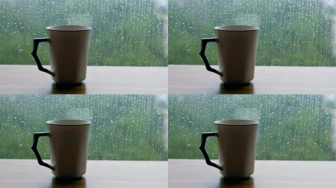 木制桌子上的咖啡杯，带有雨滴背景
