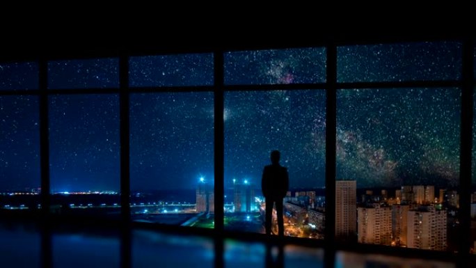 那个站在城市窗户附近的男人，有着星星的背景。时间流逝