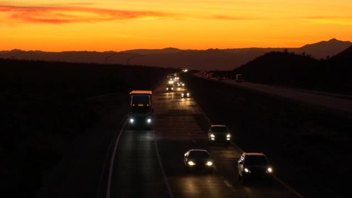空中: 通勤者和卡车司机在风景秀丽的暮色下沿着莫哈韦高速公路行驶。
