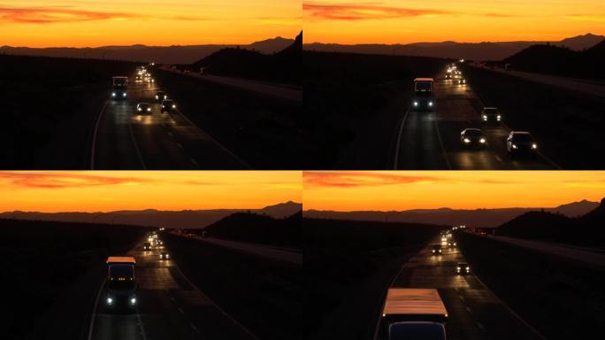 空中: 通勤者和卡车司机在风景秀丽的暮色下沿着莫哈韦高速公路行驶。
