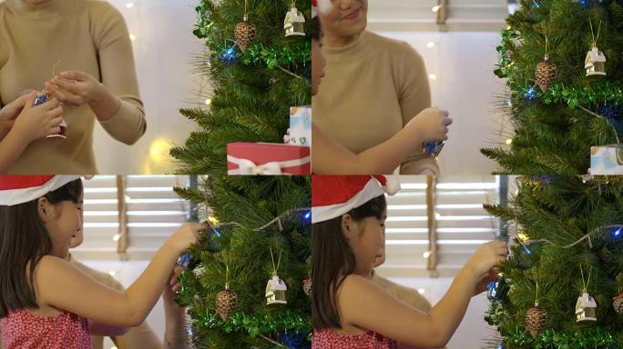 母女装饰圣诞树，年轻女孩以慢动作将装饰品放在圣诞树上