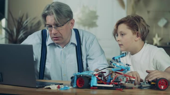 一个男孩和他的爷爷正在组装一辆玩具车