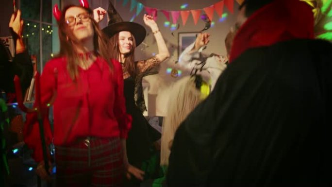 万圣节服装派对: 一群怪物在装饰有迪斯科球灯的房间里跳舞。脑死亡僵尸，吸血鬼德古拉，木乃伊，美丽的女