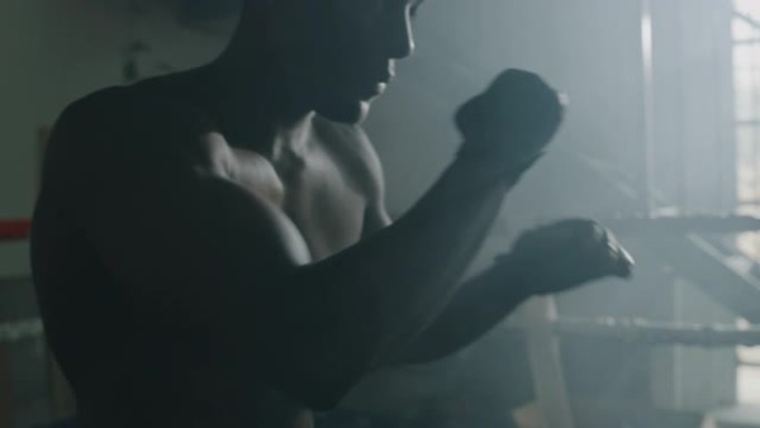 一名专业的年轻肌肉光着膀子的非洲男子的电影慢动作镜头正在带戒指的健身房练习太极拳锻炼