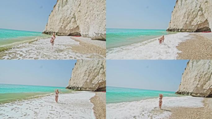 女士顽皮的年轻女子在意大利普利亚阳光明媚的绿松石海浪中嬉戏