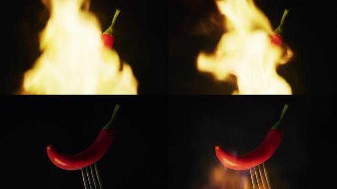 用叉子握住红辣椒的特写镜头，背景是火。