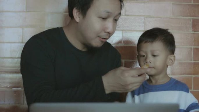 亚洲单身爸爸的4k慢动作镜头在现代阁楼房子里为男孩提供幸福生活，以实现自我学习或家庭学校，家庭和童年