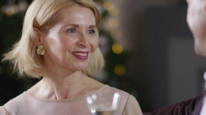 快乐的高加索女士在圣诞节派对上与香槟聊天