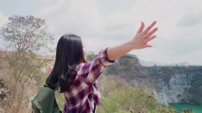 慢动作-徒步旅行者亚洲背包客女人走到山顶，女性享受她的假期徒步旅行冒险感觉自由。生活方式女性在自由时