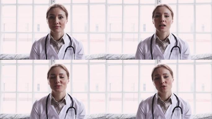 微笑的年轻女医生通过网络摄像头观看视频通话