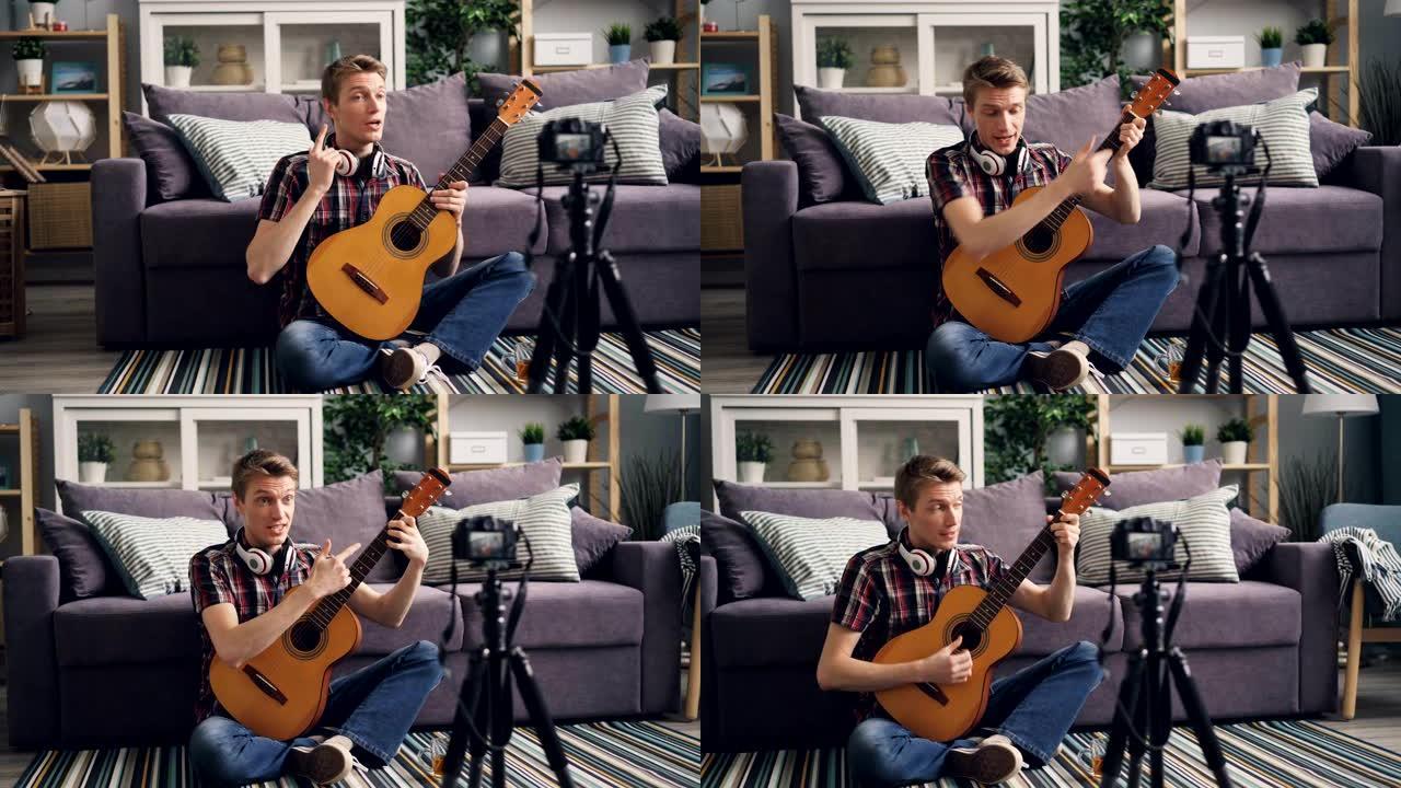 年轻的博客作者正在录制有关在家中使用相机为互联网博客弹吉他的教程