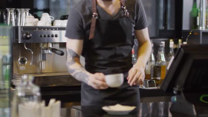 纹身的年轻男性咖啡师酿造美式咖啡并将其提供给女性