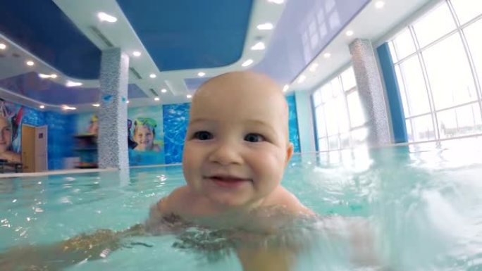 在游泳池游泳时关闭婴儿的脸