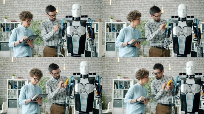 男人和女人在实验室中使用平板电脑测试现代类人机器人