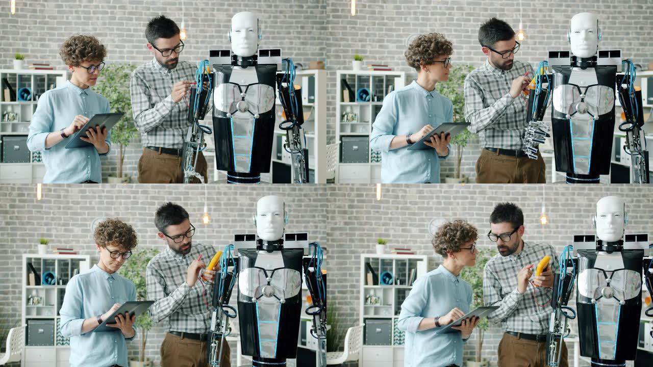 男人和女人在实验室中使用平板电脑测试现代类人机器人