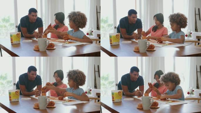 千禧一代的父亲看着他的女儿和她的女友玩模型黏土