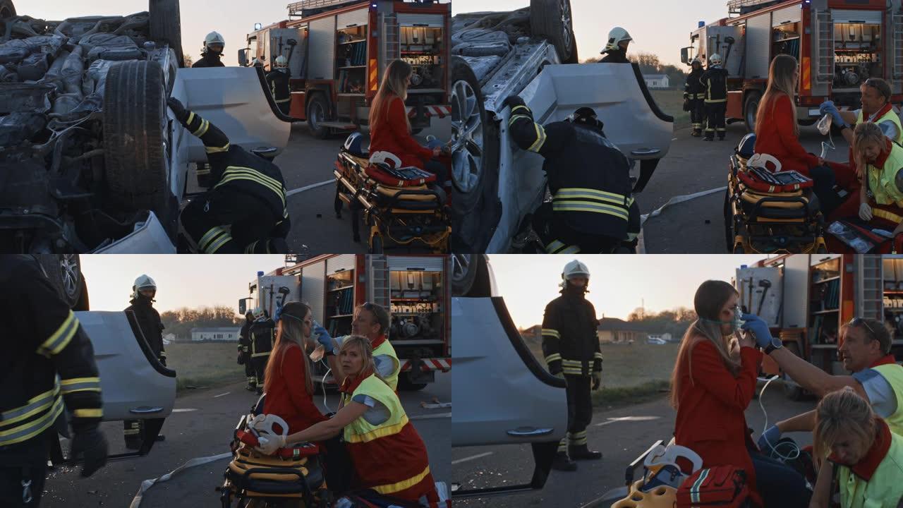 车祸交通事故: 医护人员和消防员营救受伤的被困受害者。医护人员对一名女乘客进行急救。消防员使用液压切