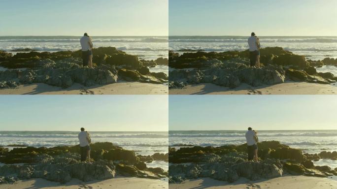 一对情侣站在4k海滩的岩石海岸上