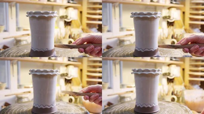 陶瓷工作室粘土花瓶上釉男性陶工设计特写
