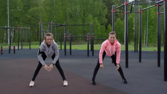 高加索双胞胎姐妹在户外健身房锻炼