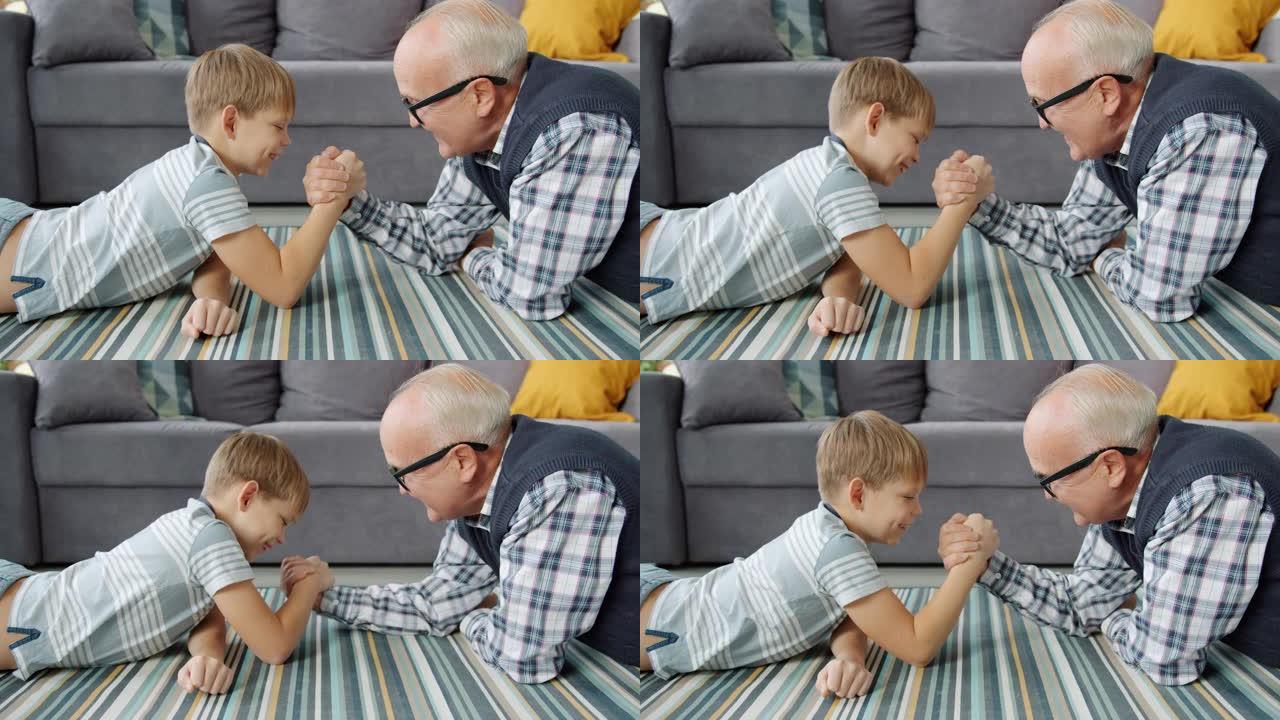 老人和小男孩在家练习手臂摔跤享受活动
