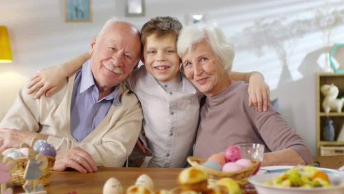 孙子拥抱祖父母微笑的肖像