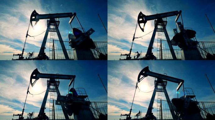 背光抽油井架在工作过程中。石油工业，石油工业，石油部门概念。