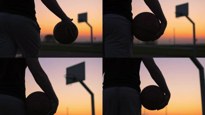 CU年轻人带着篮球在黄昏时走出室外篮球场
