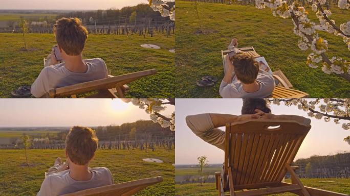 带着智能手机的曼女士在阳光明媚的田园诗般的山坡上的躺椅上放松。这个人正在躺椅上休息。
