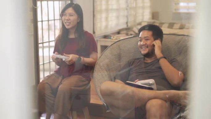 在新型冠状病毒肺炎或电晕病毒情况下，亚洲夫妇一起玩视频游戏的俯仰手持镜头