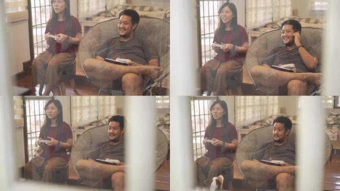 在新型冠状病毒肺炎或电晕病毒情况下，亚洲夫妇一起玩视频游戏的俯仰手持镜头