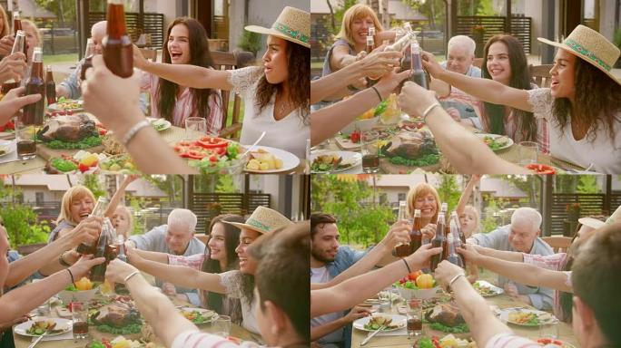 家人和朋友聚集在餐桌旁，举起玻璃杯和瓶子敬酒并碰杯。大家庭花园派对庆典。