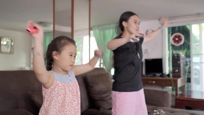 亚洲女孩在电视机前跳舞，在客厅玩电子游戏