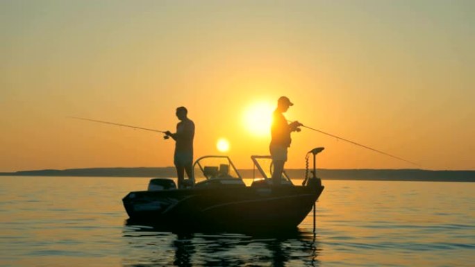 日出时，两名渔民站在船上抓鱼