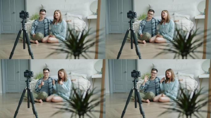 女孩和男孩视频记录器为视频日志记录视频，显示在家里竖起大拇指说话