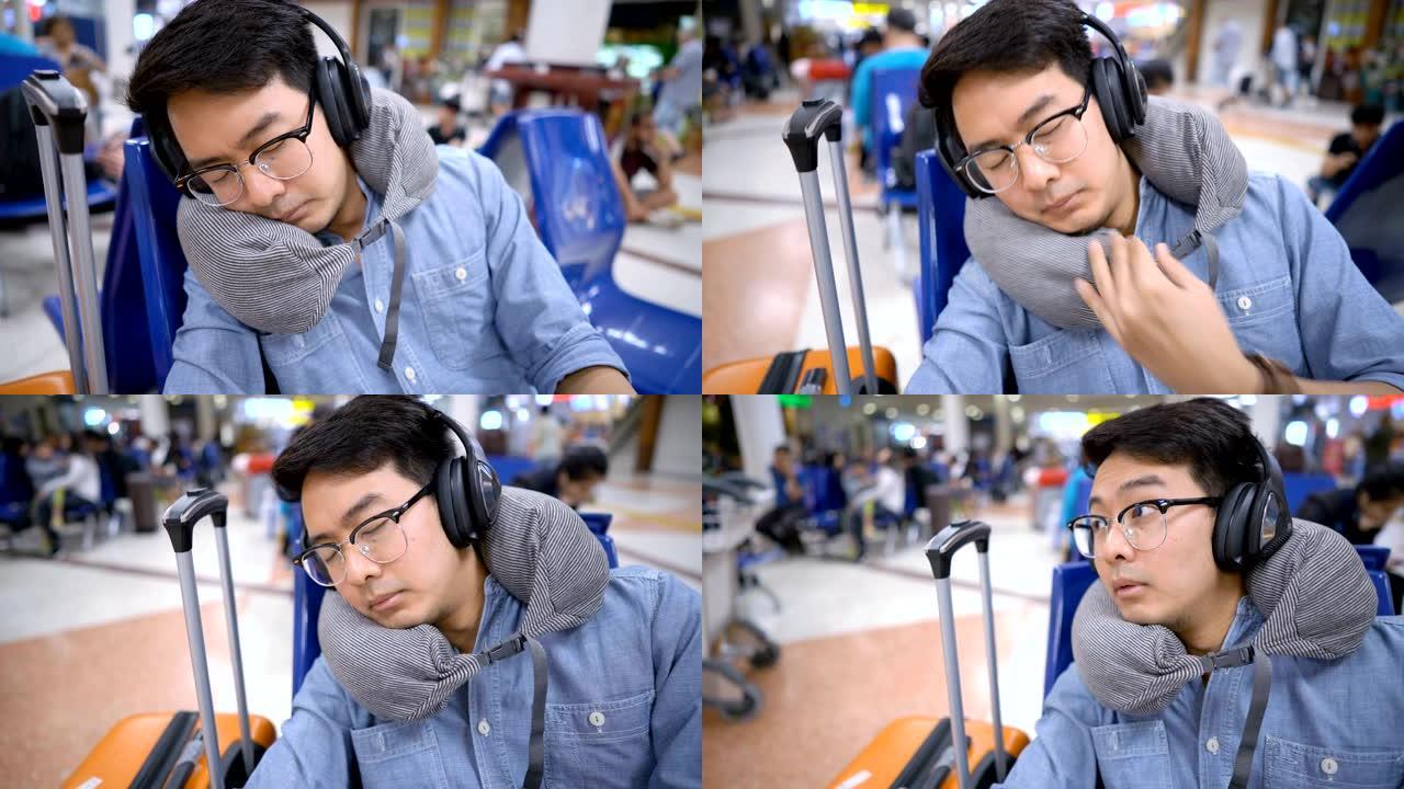 亚洲男子睡在机场出发区的旅行颈枕上，因为航班延误